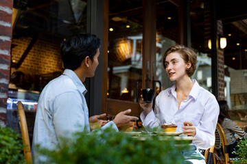 Couple have a date at european style cafe bistro enjoying morning vibe around the city square with sweet pastry and cup of coffee