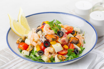 Italian mixed seafood salad. Insalata di mare. Calamari, shrimp, clams, tomatoes, bell pepper, parsley and olives..