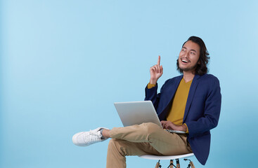 Young asian businessman thinking. While her using laptop sitting on  chair and looking isolate on...