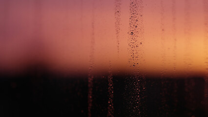 Naklejka na ściany i meble Water drops on window glass with sunset light
