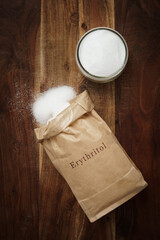 bag of erythritol sweetener on wooden background.