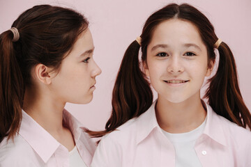 Portrait of 12 year old twin girls. One is straight, other in profile