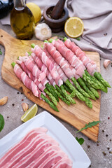 cooking green aspargus covered with bacon at domestic kitchen