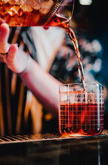 woman hand bartender making negroni cocktail in bar