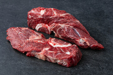 Fresh and raw fillet meat. Whole piece of beef tenderloin steaks set on black stone table background, no decoration