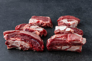 Raw beef meat osso buco shank steak, italian ossobuco. Black background