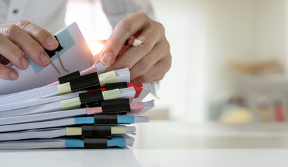 Businessman hands working on Stacks of paperwork for on his desk at home, work from home concept,...