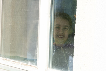 young girl looking from window