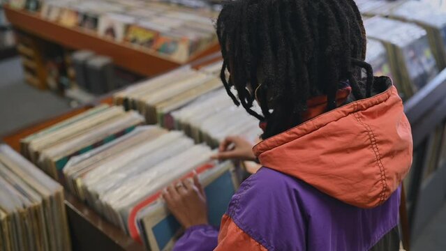 Rear view of young woman looking through vinyl records
