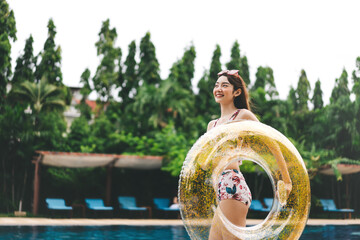 Happy smile young adult asian woman at hotel swimming pool