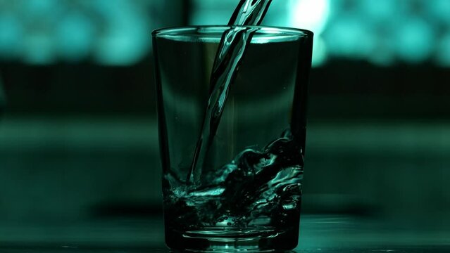 Pouring water into transparent glass in slow motion. Concept pour water. Select focus 4K resolution.