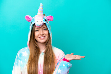 Young caucasian girl with unicorn pajamas holding pillow  smiling with a sweet expression © luismolinero