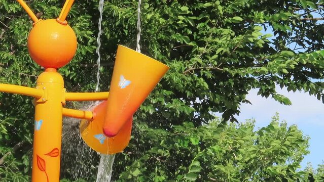 A close up to a orange waterpark shower play structure at an amusement water park