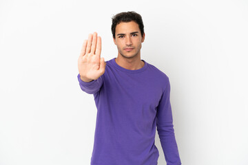 Naklejka premium Caucasian handsome man over isolated white background making stop gesture