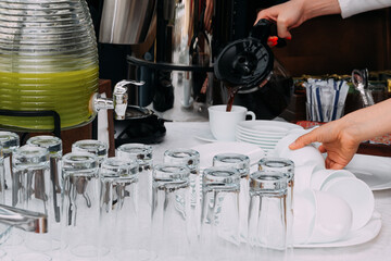 Lunch break. A man pours coffee into a cup.
