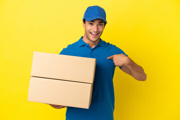 Delivery man over isolated yellow wall with surprise facial expression