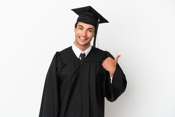 Young university graduate over isolated white background pointing to the side to present a product
