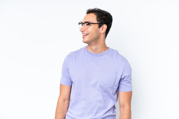 Fototapeta premium Young caucasian man isolated on white background looking to the side and smiling