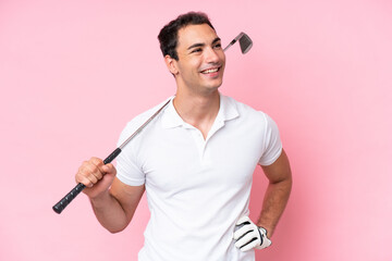 Young golfer player man isolated on pink background posing with arms at hip and smiling