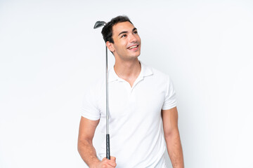 Young caucasian man isolated on white background playing golf and looking up while smiling