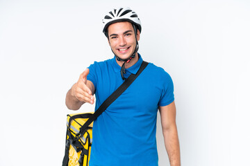 Young caucasian man with thermal backpack isolated on white background shaking hands for closing a good deal