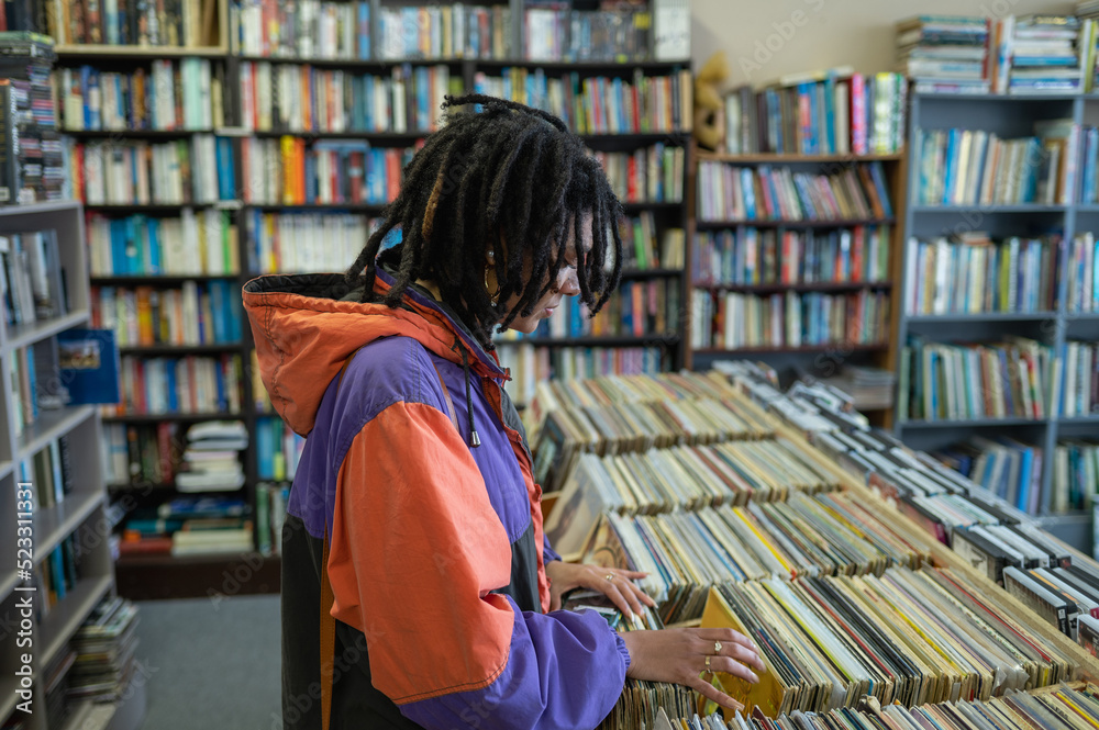 Wall mural woman seen searching through vinyl records