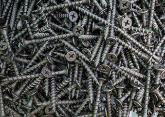 the background consists of a pile of black screws. the concept of construction and repair