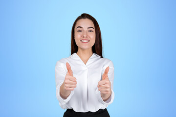 Happy businesswoman with thumbs up on blue background. Copy space