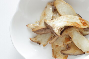 Pan fried Japanese  oyster mushroom slices on plate with copy space