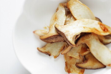 Pan fried Japanese  oyster mushroom slices on plate with copy space