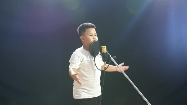 Young Asian Boy Rapping Into A Condenser Microphone On The Black Background
