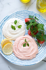Greek meze made of fish roe or taramosalata served on a blue and white plate, middle close-up, elevated view, vertical shot