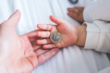 Inflation and financial security concept: Close up of newborn baby holding a euro coin