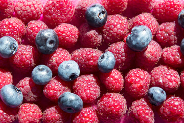 Close up view of fresh ripe mixed raspberries and blueberries
