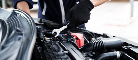 Automobile mechanic repairman hands repairing a car engine automotive workshop with a wrench, car...