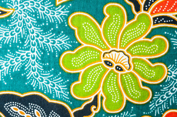Fototapeta na wymiar Closeup green flower on batik sarong pattern background in Thailand