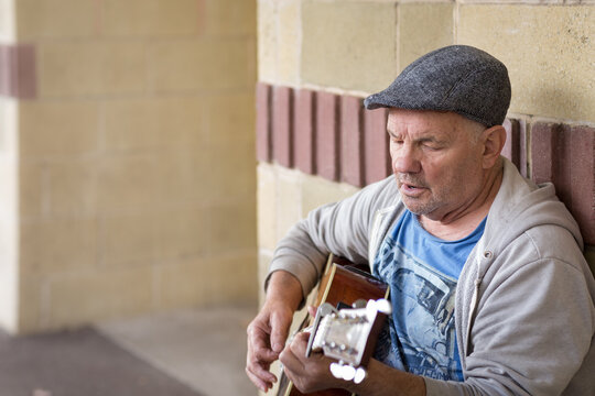 Old guy singing and playing guitar