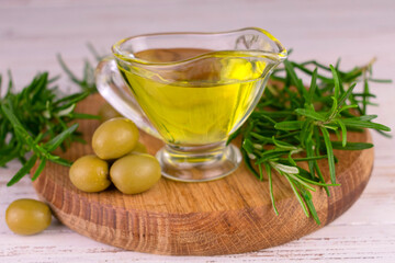 Organic olive oil in a gravy boat and fresh rosemary.
