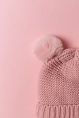 Knitted children's hat with pumpon top view. Stylish monochrome concept of knitted pieces with space for text
