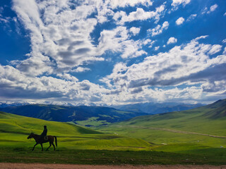 Kazakh farmer on his horse in the mountains, Almaty region.
