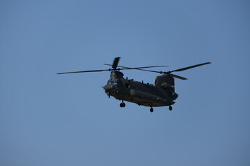Fototapeta na wymiar Aerial Titans: Majestic Flight of a Chinook Helicopter Soaring through the Skies