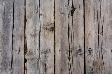 Texture of ground wooden planks. Old wood damaged by time and cracks along the boards.