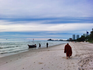 Buddhist monk walking on Hua Hin beach early morning, Thailand. 