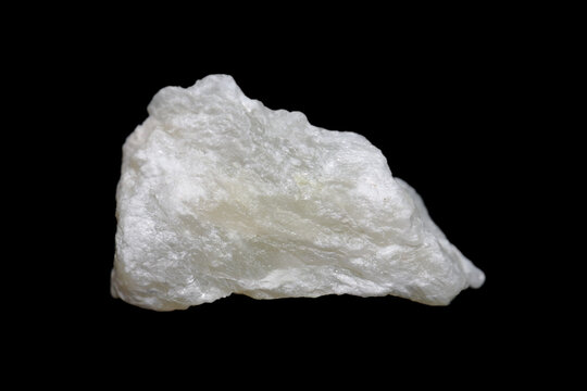Raw Talc (talcum) stone on dark background, talc is a clay mineral used in many industries ex. powder, cosmetic, paint  