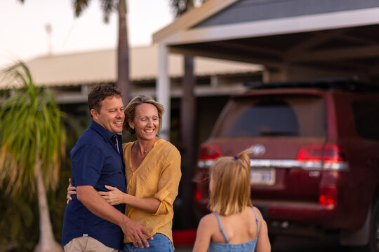 couple outside home being approached by child