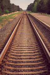 Fototapeta premium The old railway sleepers and rails extending into the distance