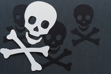 skull and crossbones shapes on dark gray paper