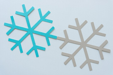 two paper snowflakes on paper