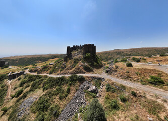 Fototapeta na wymiar panoramic view of a mountain landscape with an old dilapidated fortress against the sky in Armenia taken from a drone