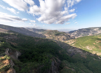 Fototapeta na wymiar panoramic views of ancient temples and buildings in picturesque places in a gorge in the mountains of Armenia taken from a drone